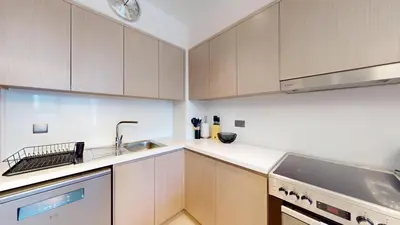a kitchen with wooden cabinets and a sink at Act One Act Two - Exquisite One Bed in Downtown in Dubai