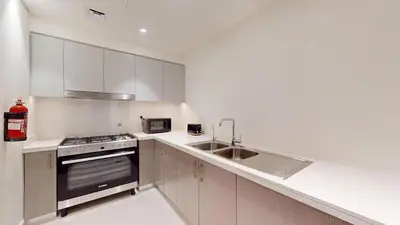 a white kitchen with a sink and a stove at Forte Tower - Aesthetic Three Bedroom in Downtown in Dubai