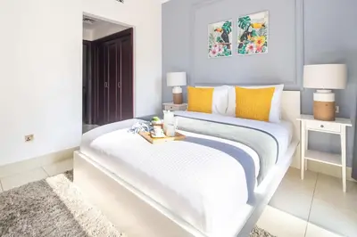 a white bedroom with a large bed with a tray on it at Frank Porter - Yansoon 5 in Dubai