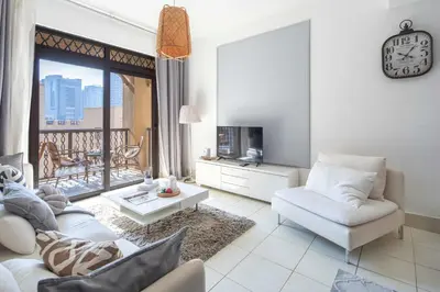 a living room with a white couch and a clock at Frank Porter - Yansoon 5 in Dubai