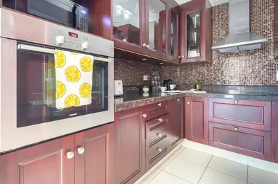 a kitchen with red cabinets and a microwave at Frank Porter - Yansoon 5 in Dubai