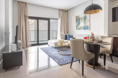 a living room with a table and a couch at Frank Porter - Damac Majestine in Dubai
