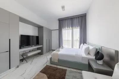 a hotel room with a bed and a television at Brand New Studio 15 mins drive from Business Bay in Dubai