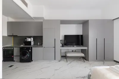 a room with a kitchen with a microwave and a tv at Brand New Studio 15 mins drive from Business Bay in Dubai