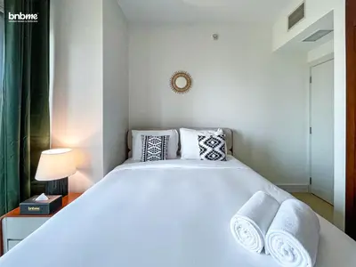 a bedroom with a large white bed with pillows at bnbmehomes - Golf Tower 1 in Dubai