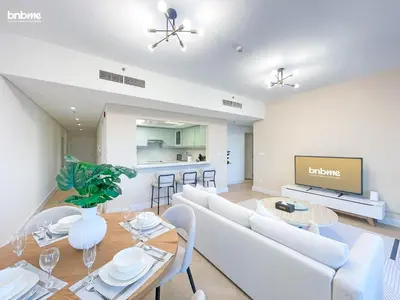 a living room with a white couch and a tv at bnbmehomes - Golf Tower 1 in Dubai