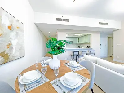 a dining room with a table and a couch at bnbmehomes - Golf Tower 1 in Dubai