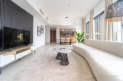 a living room with a white couch and a tv at Beautiful & Spacious 3 Bedroom Wmaids In Marina in Dubai