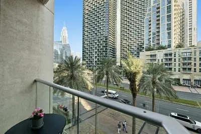 a balcony with a view of a city with palm trees at 1 BR Exquisite Urban Living in Downtown Dubai in Dubai