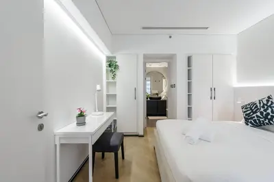 a white bedroom with a desk and a bed at 1 BR Exquisite Urban Living in Downtown Dubai in Dubai