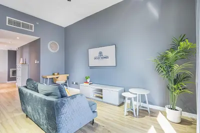 a living room with blue walls and a blue couch at Stylish & Compact Home in the Heart of the JVC in Dubai