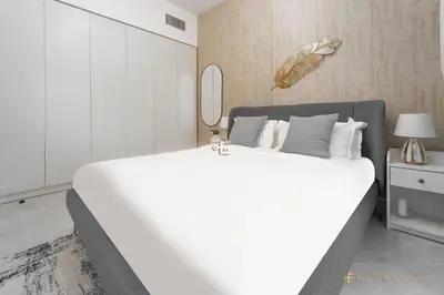 a large white bed in a room with a mirror at 1-bedroom Apartment In Binghatti Avenue in Dubai