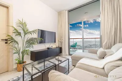 a living room with a tv and a large window at 1-bedroom Apartment In Binghatti Avenue in Dubai