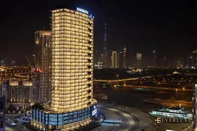 a lit up building in a city at night at 1-bedroom Apartment In Binghatti Avenue in Dubai