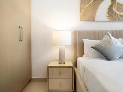 a bedroom with a bed and a lamp on a night stand at Park View Stay at Creek Horizon in Dubai