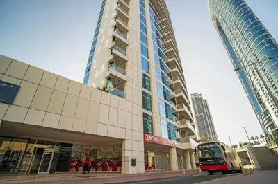 a bus is parked in front of a building at 13 - Stylish Dorra Bay Family Apartment - Canal View & Pool Access in Dubai