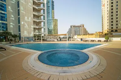 a swimming pool in a city with tall buildings at 13 - Stylish Dorra Bay Family Apartment - Canal View & Pool Access in Dubai