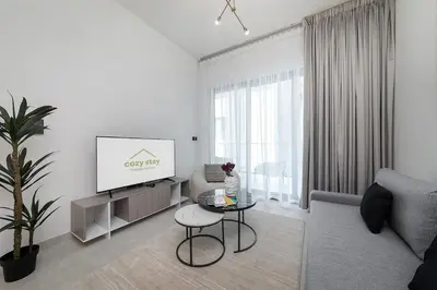 a white living room with a tv and a table at Cozy 1BR apartment Binghatti Canal Business Bay in Dubai