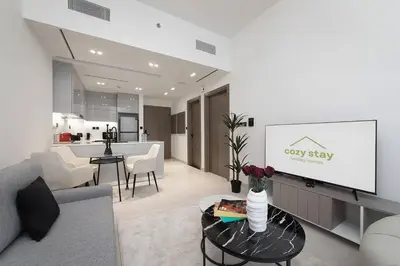 a living room with a couch and a table with a tv at Cozy 1BR apartment Binghatti Canal Business Bay in Dubai