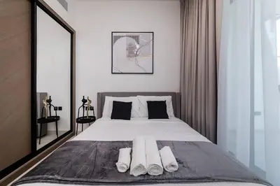 a bedroom with a large bed with towels on it at Cozy 1BR apartment Binghatti Canal Business Bay in Dubai