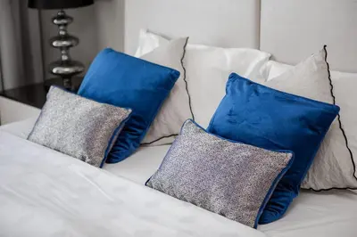 four pillows sitting on a white couch at Modern 1BR apartment Artesia DAMAC Hills in Dubai