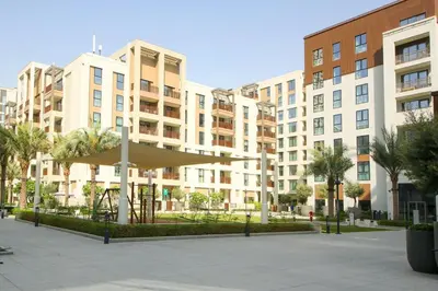 a group of buildings with palm trees in a courtyard at Breeze haven residences- 2BHK brand new furnished apartment in Dubai