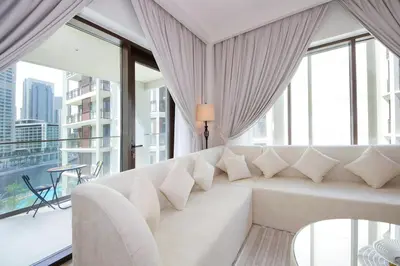 a white couch in a room with large windows at Breeze haven residences- 2BHK brand new furnished apartment in Dubai