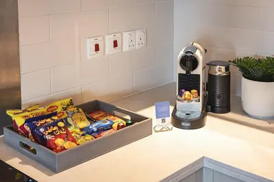 a kitchen counter with a box of snacks and a blender at The Boulevard Suite Luxury near Burj Khalifa in Dubai