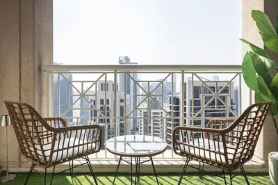 three chairs and a table in front of a window at The Boulevard Suite Luxury near Burj Khalifa in Dubai