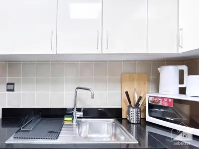 a kitchen counter with a sink and a microwave at Your Perfect Meydan Getaway 1B Polo Residence C3 in Dubai