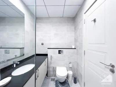 a white bathroom with a toilet and a sink at Your Perfect Meydan Getaway 1B Polo Residence C3 in Dubai