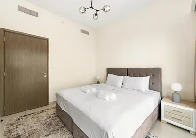 a bedroom with a large bed with two towels on it at Burj Royale Dubai Downtown in Dubai