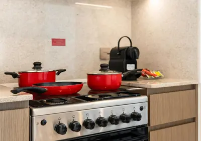 two red pots sitting on top of a stove at Burj Royale Dubai Downtown in Dubai