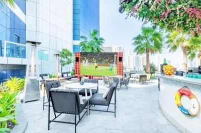a patio with a table and chairs on a building at Prime 1BR Location Minutes to Burj Dubai Mall by Vibel in Dubai