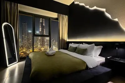 a bedroom with a large bed with a view of a city at Luxury At The Top- Iconic Burj Views-Dubai Mall Access 2BR by Maxx Value Homes in Dubai