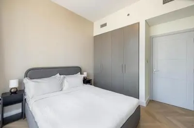 a bedroom with a white bed and a closet at Apartment Downtown Dubai in Dubai