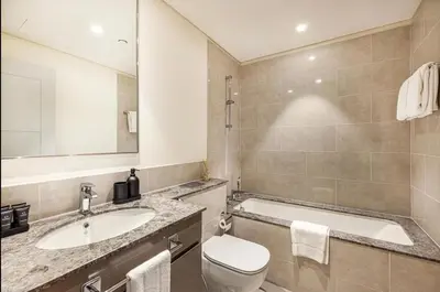 a bathroom with a sink and a toilet and a tub at Apartment Downtown Dubai in Dubai