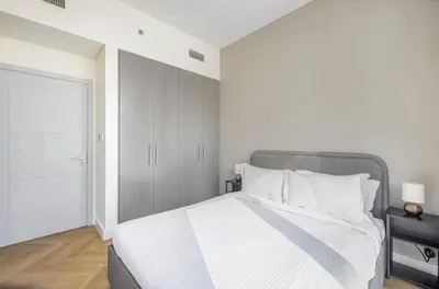 a bedroom with a large bed with white sheets and pillows at Apartment Downtown Dubai in Dubai