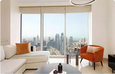 a living room with a couch and a chair and a large window at Penthouse Downtown Dubai in Dubai