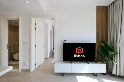 a living room with a tv on top of a table at Livbnb-Modern Living 1B Apartment in JVC in Dubai