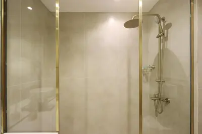 a shower with a glass door in a bathroom at Livbnb-Modern Living 1B Apartment in JVC in Dubai