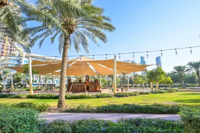 a large tent in a park with a palm tree at Livbnb-Modern Living 1B Apartment in JVC in Dubai