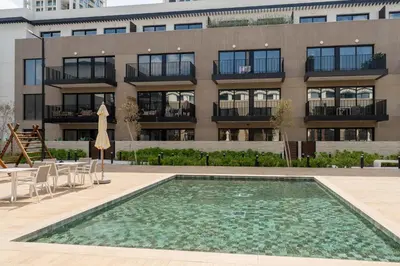a building with a swimming pool in front of a building at Urban Studio With Pool & Tennis Court in Dubai