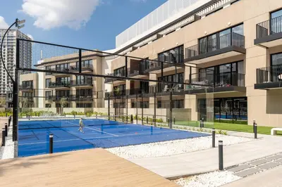 a tennis court in front of a building at Urban Studio With Pool & Tennis Court in Dubai