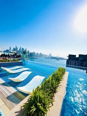 a swimming pool with chaise lounges in a resort at Infinity Pool Studio in Palm Jumeirah on Exclusive West Beach in Dubai