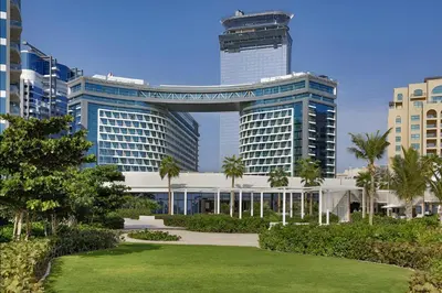 a view of a building with palm trees and a park at Infinity Pool Studio in Palm Jumeirah on Exclusive West Beach in Dubai