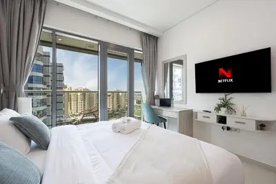 a bedroom with a bed with a tv and a window at Infinity Pool Studio in Palm Jumeirah on Exclusive West Beach in Dubai