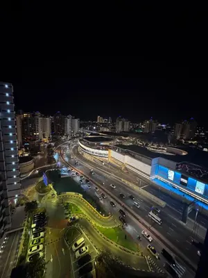a busy city street at night with buildings and cars at Infinity Pool Studio in Palm Jumeirah on Exclusive West Beach in Dubai