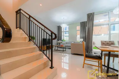 a living room with a staircase and a dining room at Prestine 3BR Villa in DH2 by deleguest in Dubai