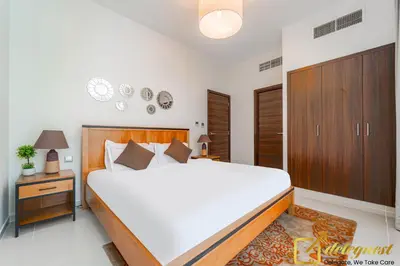 a bedroom with a large white bed and wooden cabinets at Prestine 3BR Villa in DH2 by deleguest in Dubai